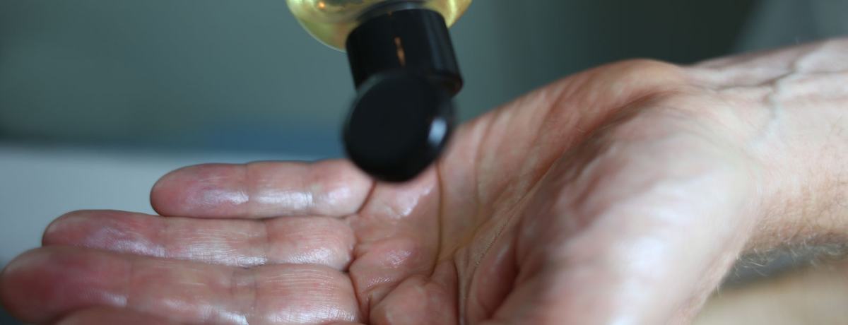 Warme massageolie wordt in de handpalm van de masseur geschonken