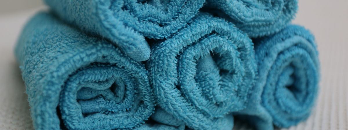 Opgerolde blauwe handdoeken, klaar voor een massage aan huis